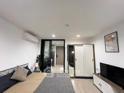 Modern bedroom with stylish decor, featuring a cozy bed, wardrobe, and air conditioning.