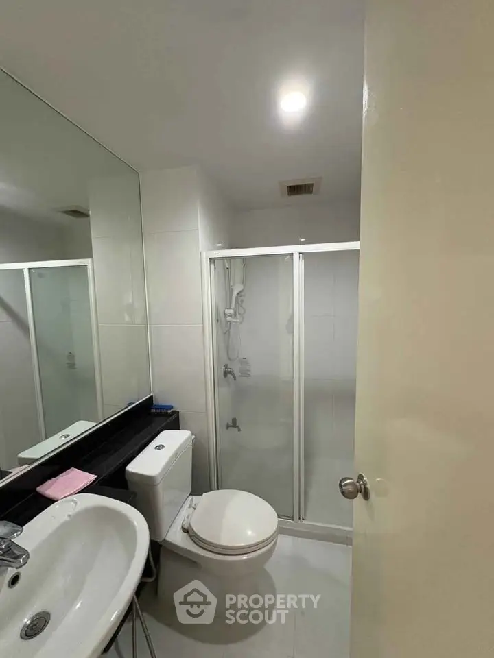 Modern bathroom with glass shower enclosure and sleek fixtures
