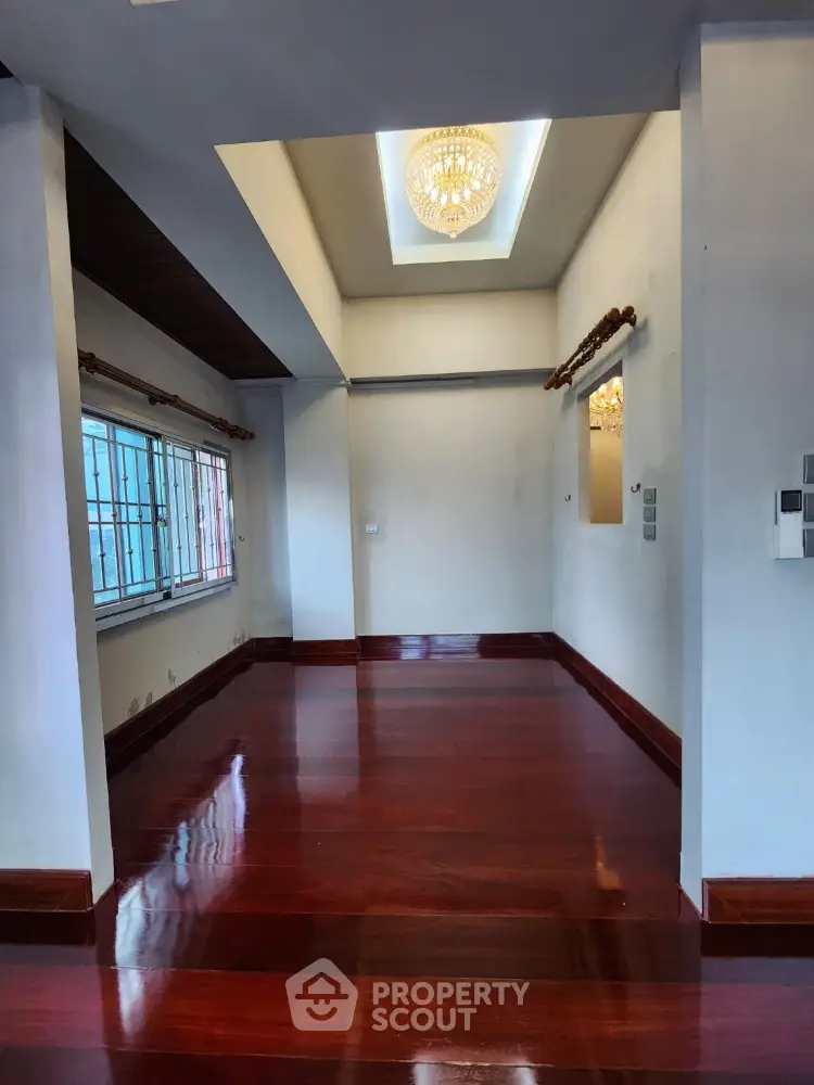 Elegant interior with polished wooden floors and chandelier, perfect for a stylish living space.