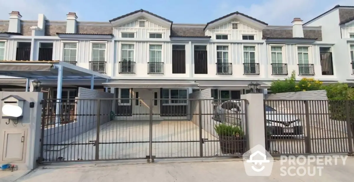 Charming townhouse exterior with gated driveway and classic architectural design.