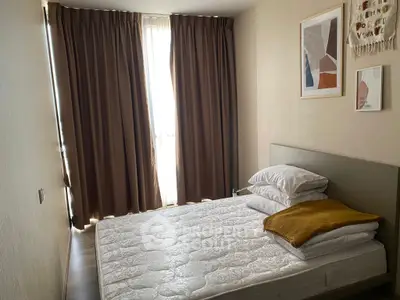 Cozy bedroom with modern decor and natural light through large window.