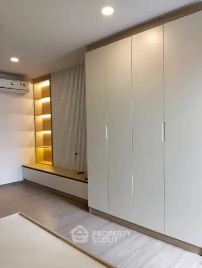 Modern bedroom with sleek built-in wardrobe and ambient lighting