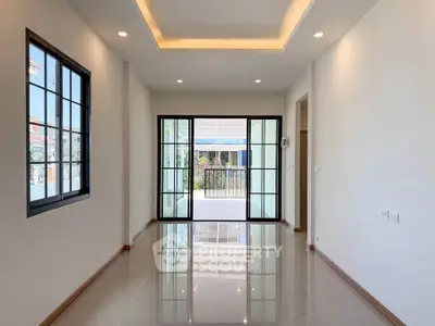 Spacious modern living room with large windows and sleek tile flooring