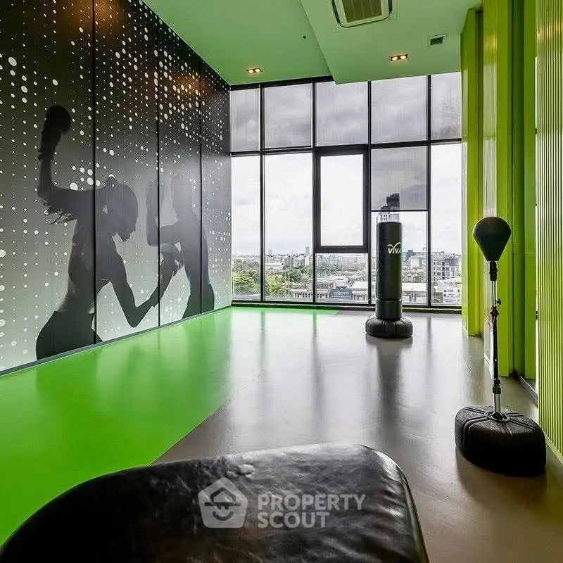 Modern gym with floor-to-ceiling windows and boxing equipment in a high-rise building.