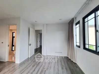 Spacious modern bedroom with large windows and sleek flooring