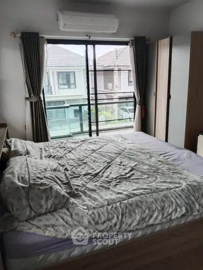 Cozy bedroom with large window and balcony view in modern home