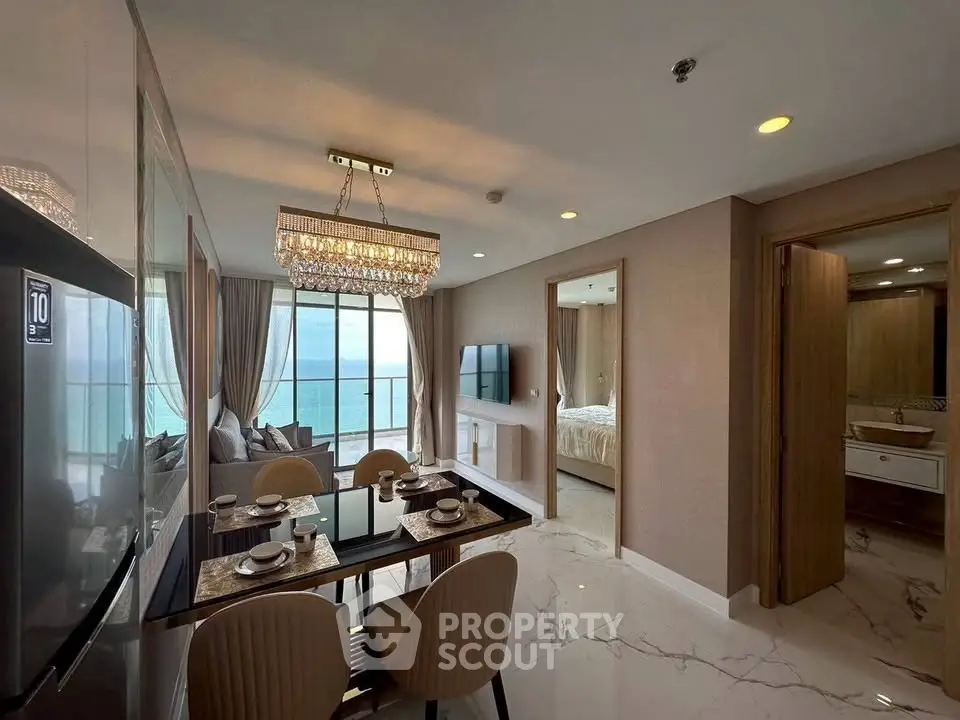 Luxurious open-plan living and dining area with stunning ocean view and elegant decor.