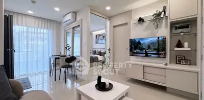 Modern living room with open layout and stylish decor, featuring a cozy seating area and a wall-mounted TV.