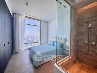 Luxurious bedroom with stunning city view and modern glass shower