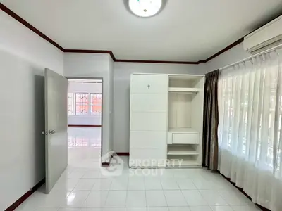 Spacious bedroom with built-in wardrobe and large window for natural light