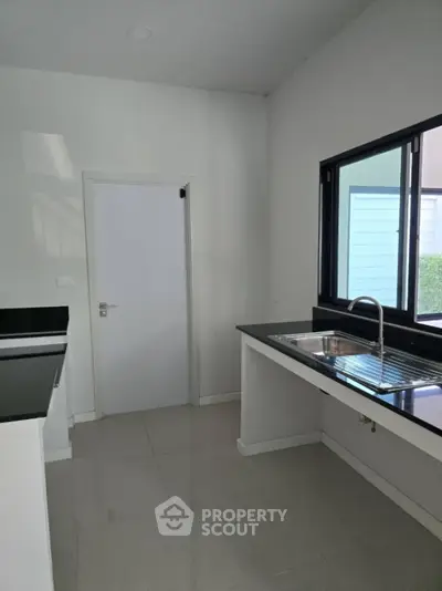 Modern kitchen with sleek countertops and large window for natural light