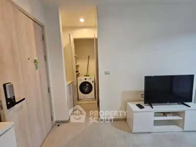 Modern apartment interior with washing machine and TV setup