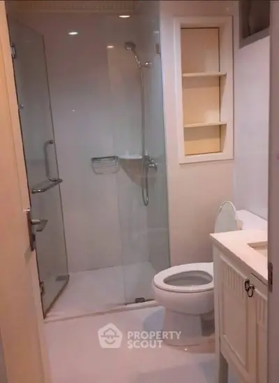 Modern bathroom with glass shower and sleek fixtures in a contemporary home.