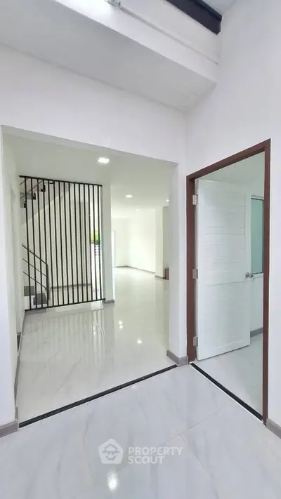 Modern open-concept interior with sleek white finishes and stylish staircase