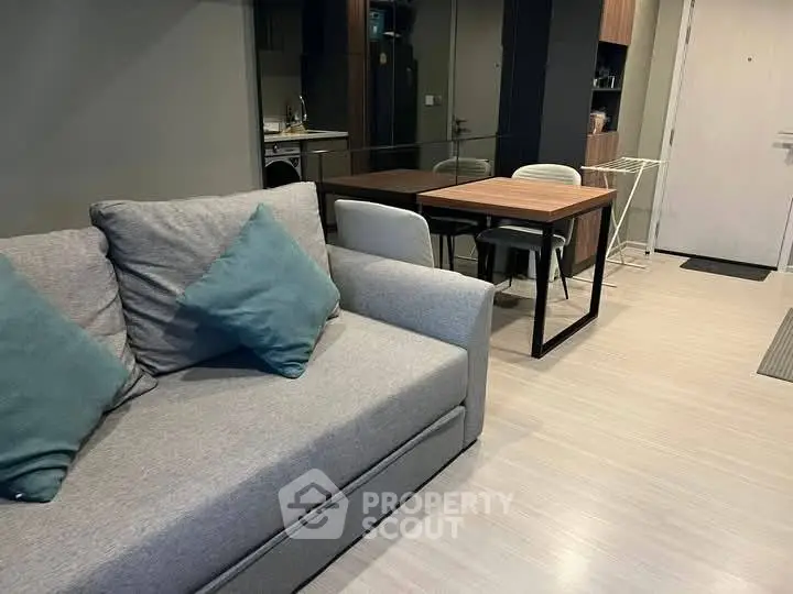 Modern living room with cozy sofa and dining area in open layout apartment.