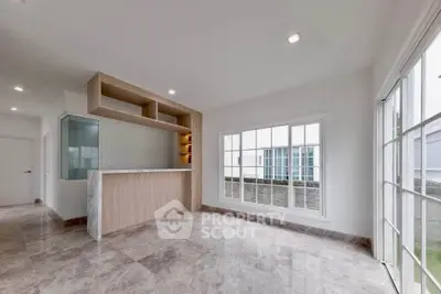 Spacious modern living room with large windows and marble flooring