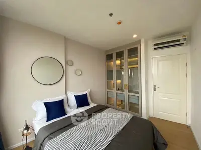 Modern bedroom with stylish decor and ample storage in a cozy apartment.