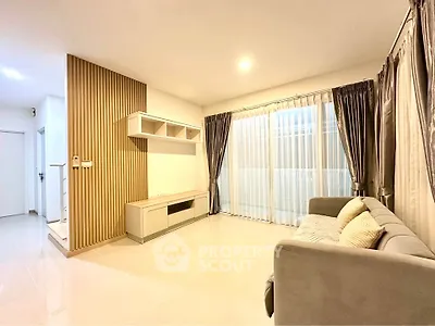 Spacious living room with modern decor and large windows for natural light.