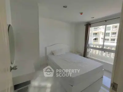 Bright and airy bedroom with large window and minimalist decor in modern apartment.