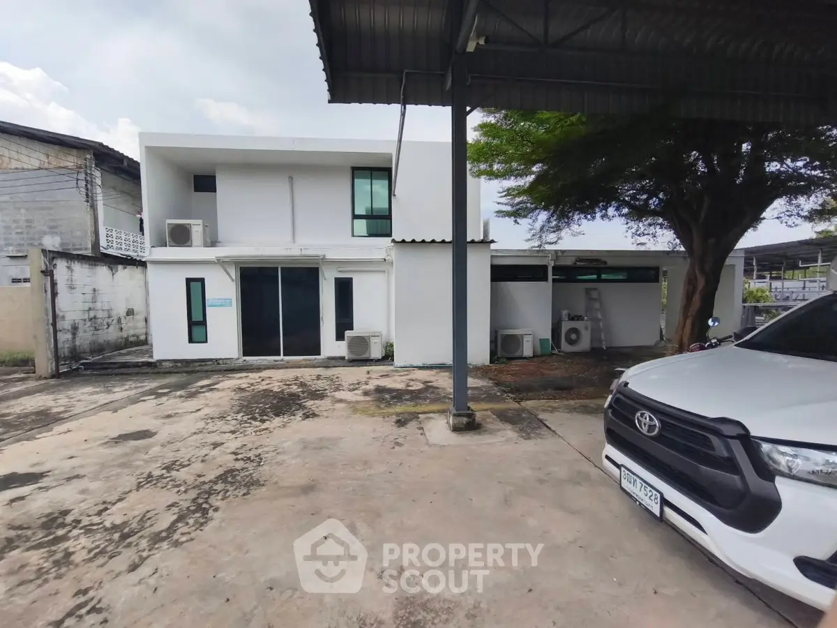 Modern two-story building with spacious parking area and sleek design.