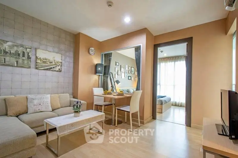 Modern living room with cozy seating and dining area, leading to a bright bedroom.