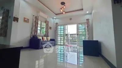 Spacious living room with modern lighting and large windows for natural light.