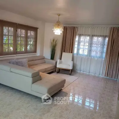 Elegant living room with modern furniture and large windows, perfect for relaxation and entertaining.