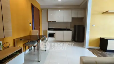 Modern kitchen with sleek cabinetry and dining area in a bright apartment