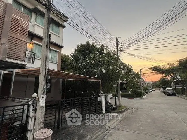 Charming suburban street view with modern townhouses at sunset, ideal for peaceful living.