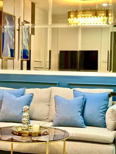 Luxurious living room with elegant decor and plush blue pillows on a stylish sofa.