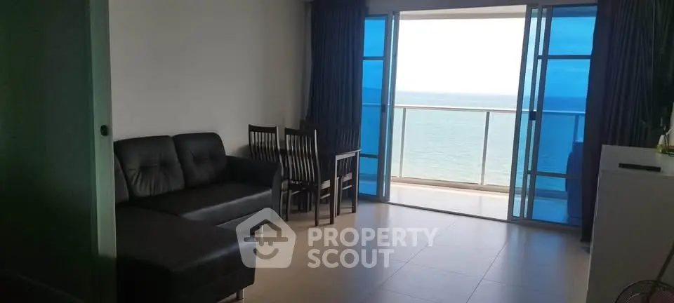 Spacious living room with ocean view and balcony access in modern apartment.