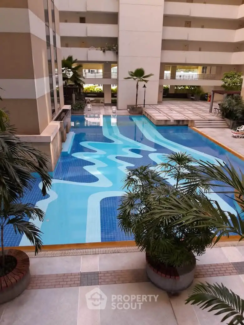 Luxurious residential complex with stunning swimming pool and lush greenery.