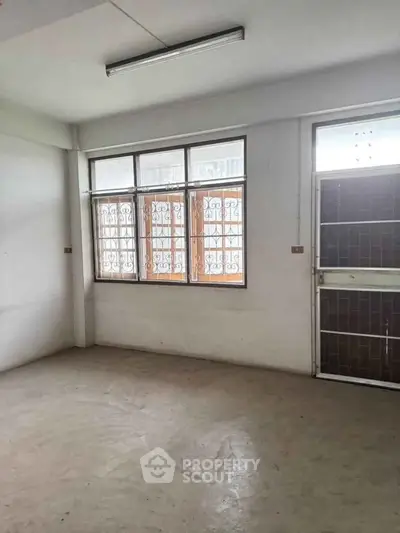 Spacious unfurnished room with large windows and natural light, perfect for customization.