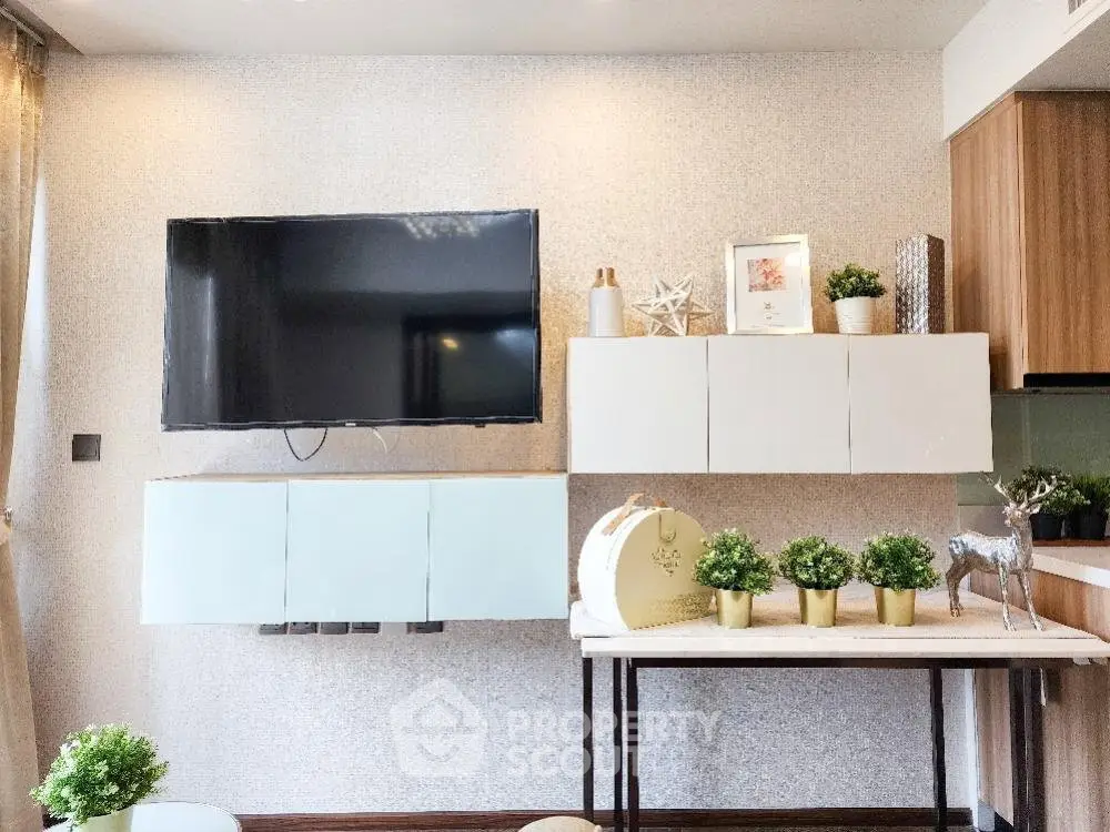 Modern living room with wall-mounted TV and stylish decor in a cozy apartment.