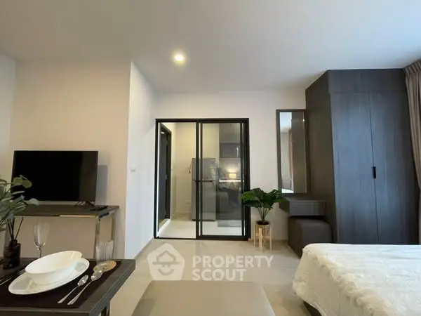Modern studio apartment with sleek design and open layout, featuring a cozy living area and stylish kitchenette.