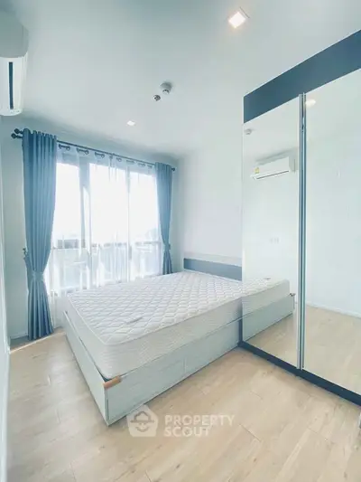 Bright and airy bedroom with large windows and mirrored wardrobe