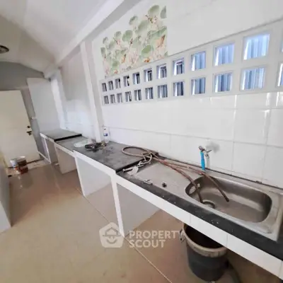 Spacious kitchen with tiled backsplash and ample counter space, ideal for culinary enthusiasts.