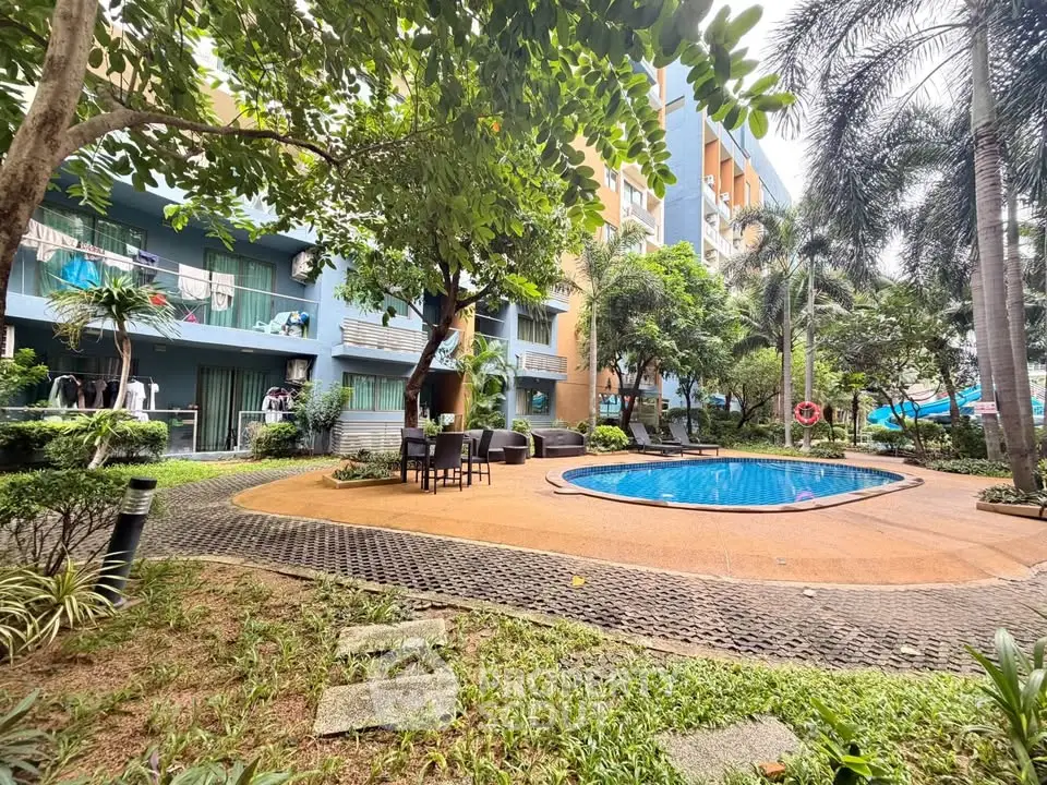 Charming residential pool area surrounded by lush greenery and modern building facade.
