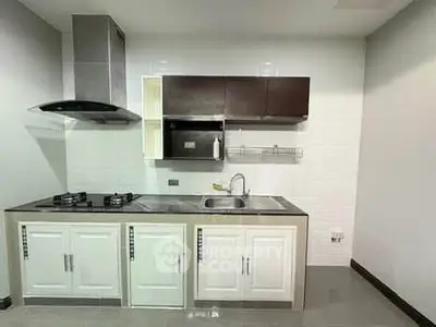 Modern kitchen with sleek cabinetry and gas stove in a compact layout.
