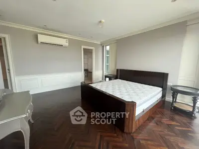 Spacious bedroom with elegant parquet flooring and modern furnishings