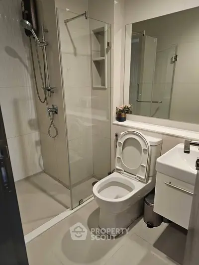Modern bathroom with glass shower and sleek fixtures in contemporary apartment.