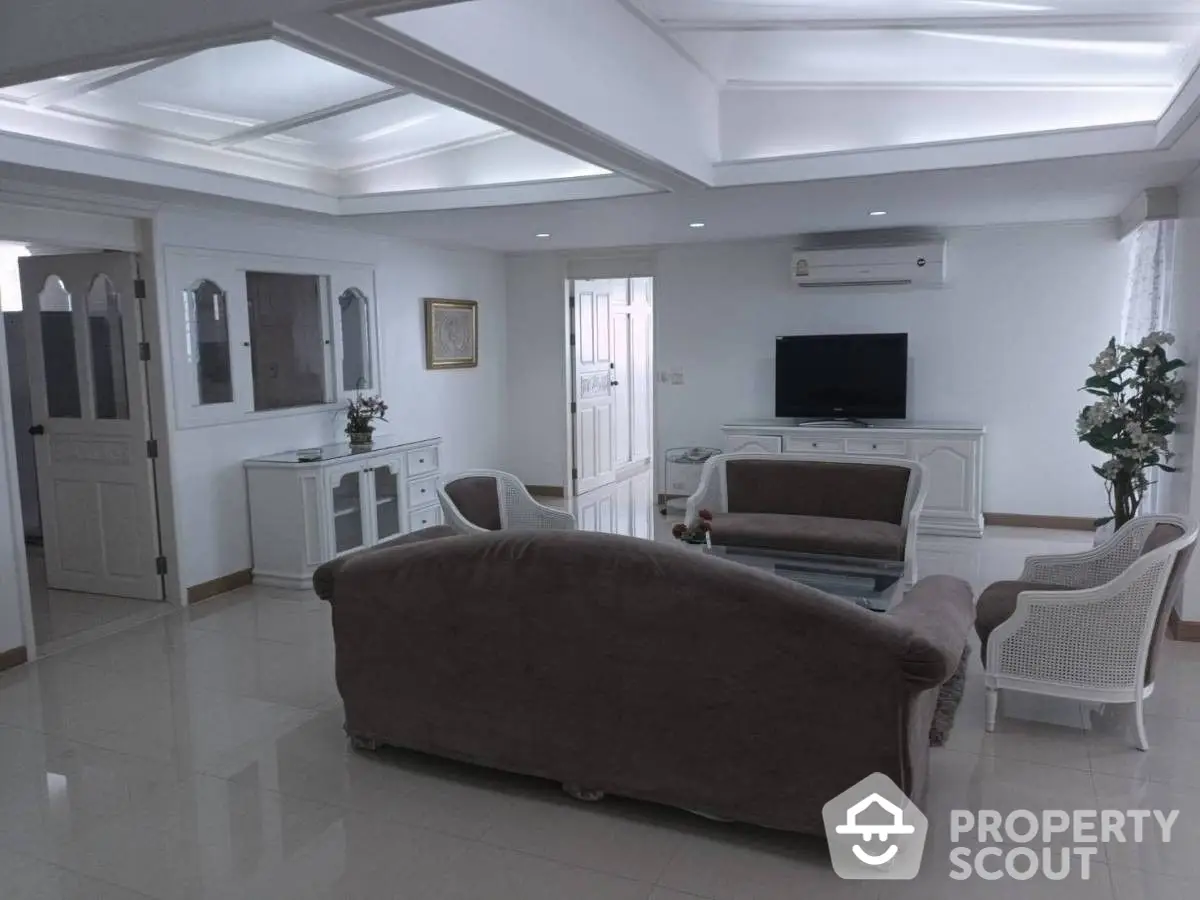 Spacious and elegant living room with glossy white flooring, plush sofas, and modern lighting fixtures, perfect for upscale living.