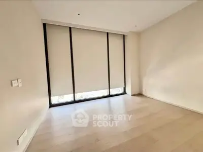 Spacious empty room with large windows and wooden flooring, perfect for customization.