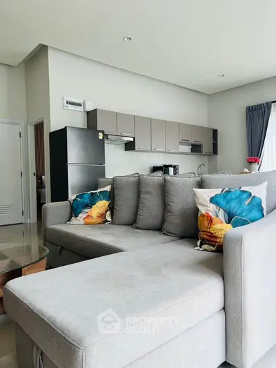 Modern living room with stylish gray sofa and open kitchen layout