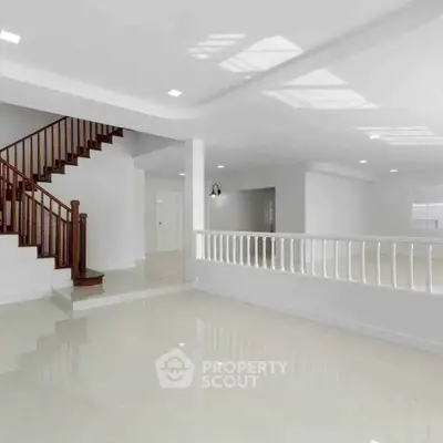 Spacious modern interior with elegant staircase and glossy flooring, perfect for stylish living.