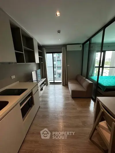 Modern apartment with open layout, featuring a cozy living area and a balcony view.