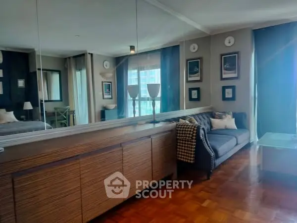 Stylish living room with modern decor and large mirror reflecting natural light.