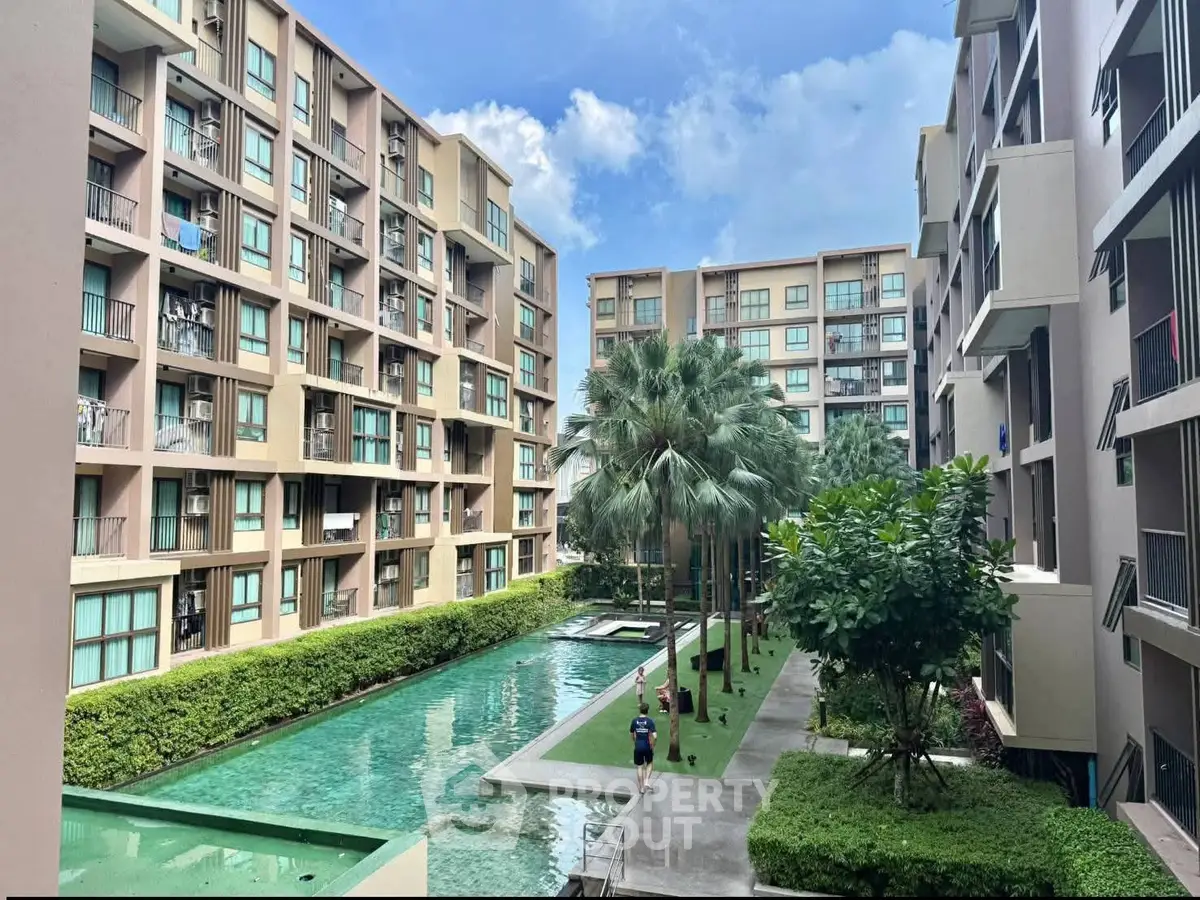 Modern apartment complex with lush greenery and pool view