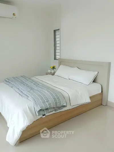 Modern minimalist bedroom with cozy bed and natural light