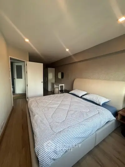 Spacious bedroom with modern decor and cozy ambiance, featuring a comfortable bed and stylish furnishings.